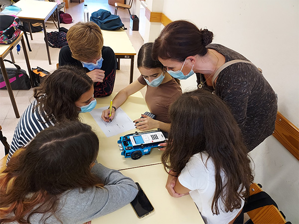 Maths teacher Olga Pestana works with students and a TI-Innovator™ Rover.